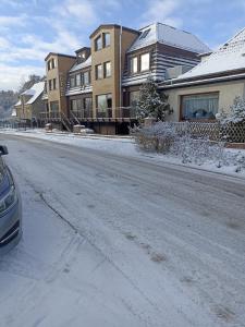 eine schneebedeckte Straße mit Häusern und einem Auto in der Unterkunft Hotel zur Panke Wohnung 2 in Kolonie Röntgental