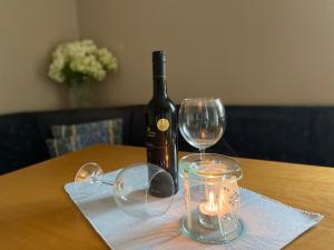 - une bouteille de vin et deux verres sur une table dans l'établissement Haus Boscher, à Pappenheim