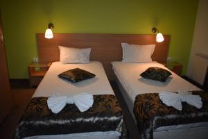 two beds with bow ties on them in a room at Green Hisar Hotel Family in Hisarya