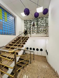 a staircase in a room with purple pendant lights at Appa Hostel in Zagreb