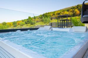 a large jacuzzi tub with water in it at Luxury Exclusive Villa Panoramica near Labin - Rabac only 2 km from the beach with sea view and wellness in Koromačno