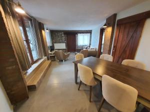 a dining room with a wooden table and chairs at Karameşe Taş Ev - Karameşe Stone House in Selçuk