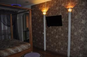 1 dormitorio con 1 cama y TV de pantalla plana en la pared en Cozy apartments near the McDonalds en Kremenchuk