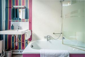 a bathroom with a sink and a bath tub at Hotel Van Eyck in Bruges