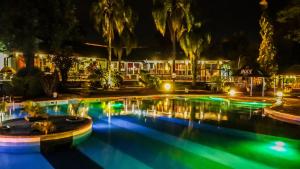 a pool at night with a hotel in the background at Beer Hotel Iguazú in Puerto Iguazú