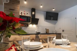 a kitchen and dining room with a table with plates and glasses at Jurajskie Pokoje Pod Lasem in Żarki