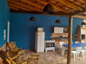 cocina azul con mesa y nevera en Pousada Chalé Boracéia, en Boracéia