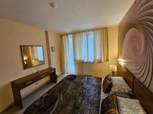 a bedroom with two beds and a mirror and a television at Enjoy Studio and Lovely Apartment Villa Park in Borovets