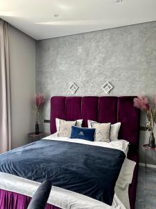 una camera con un grande letto con testiera viola di Family Residence Boutique Apartments 4 a Lviv