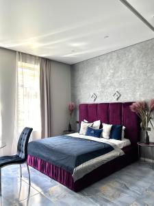 una camera con letto viola e sedia di Family Residence Boutique Apartments 4 a Lviv