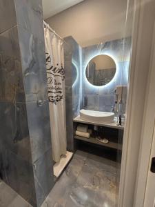 bagno con lavandino e specchio di Family Residence Boutique Apartments 4 a Lviv