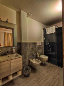 a bathroom with two sinks and a toilet and a tub at Foresteria Del Borgo Etrusco in Lonato