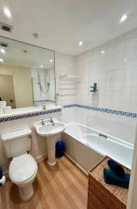 a bathroom with a toilet and a sink and a tub at KB21 Attractive 2 Bed House, pets/long stays with easy links to London, Brighton and Gatwick in Roffey