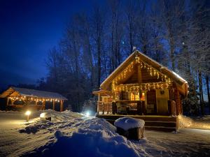una cabaña de madera con luces de Navidad encendidas por la noche en Järveoru en Aidaku