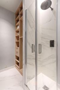 een douche met een glazen deur in de badkamer bij Champs Elysées Marbeuf Magnifique Appartement 4P in Parijs