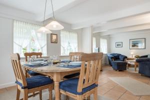 a dining room and living room with a table and chairs at Huldas Hues in Keitum