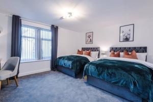 a bedroom with two beds and a window at Beautiful Bradford Home Sleeps 8 with Parking by PureStay Short Lets in Wibsey