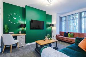 a living room with a green accent wall at Beautiful Bradford Home Sleeps 8 with Parking by PureStay Short Lets in Wibsey