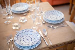 a table with blue and white plates and silverware at Kleine Kate in Keitum