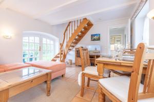 a living room with a staircase and a dining room at Kleine Kate in Keitum +15 photos