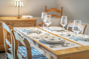 uma mesa de madeira com pratos e copos de vinho em Weefster em Keitum
