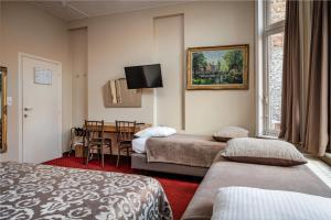 Habitación de hotel con 2 camas y mesa en Hotel Van Eyck, en Brujas