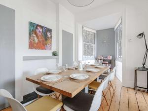 a white dining room with a wooden table and chairs at 4 bed property in Broadstairs 80679 in Broadstairs