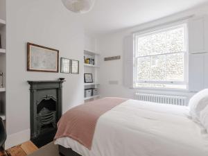 a white bedroom with a bed and a fireplace at 4 bed property in Broadstairs 80679 in Broadstairs