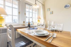 a dining room table with a plate and wine glasses at Ole Lukoeje in Keitum