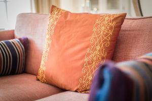 an orange pillow sitting on top of a couch at Luv Hues in Keitum