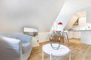 a living room with a couch and a table at Auszeit im Takerhof in Keitum