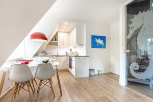 a kitchen and dining room with a table and chairs at Auszeit im Takerhof in Keitum