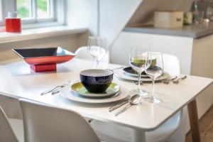 un tavolo con due bicchieri da vino e un piatto sopra di Auszeit im Takerhof a Keitum