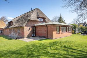 a large brick house with a thatched roof at Aalernhues in Keitum