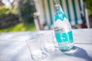 two glasses and a bottle of water on a table at Aalernhues in Keitum +40 photos