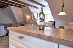 a bottle of wine and two glasses on a counter at Sharky Bay in Keitum +13 photos