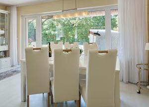 a dining room with a table and white chairs at Henning in Keitum +23 photos