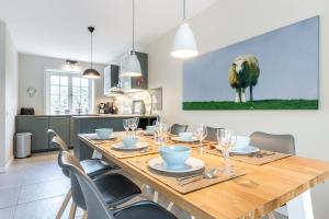 ein Esszimmer mit einem Holztisch und einem Schafgemälde in der Unterkunft Ahoi in Archsum