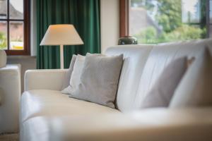 a white couch with pillows in a living room at Kirchenweg in Keitum +25 photos