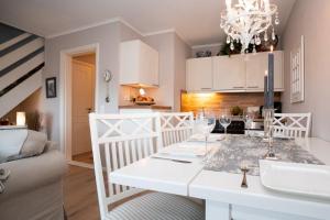 a kitchen and living room with a white dining room table at Tunghoern Hues Wohnung 07 in Keitum