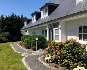 une maison avec un jardin de fleurs devant elle dans l'établissement Tunghoern Hues Wohnung 07, à Keitum