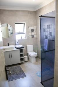 a bathroom with a toilet and a sink and a shower at Asania Guest House in Bloemfontein