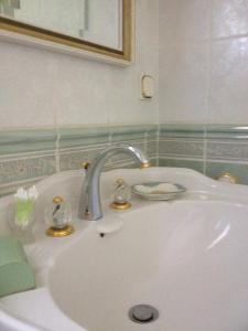 a white sink with a faucet in a bathroom at Chambres D'Hôtes Des 3 Rois in Verdun-sur-Meuse