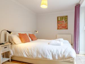 a bedroom with a white bed with orange pillows at 2 Bed in Brixham 80008 in Brixham