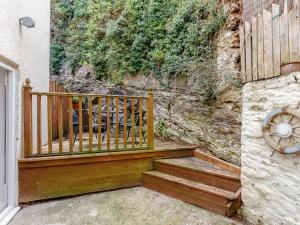 a wooden staircase next to a building with a stone wall at 2 Bed in Brixham 80008 in Brixham