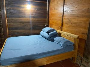 a small bed with blue pillows on top of it at Ha Giang Lake View House in Ha Giang