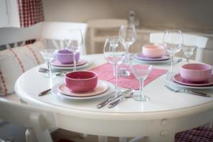 uma mesa branca com pratos e copos de vinho em Rotes Kliff em Keitum