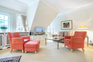 ein Wohnzimmer mit zwei Stühlen und einem Tisch in der Unterkunft Tüchter in Keitum