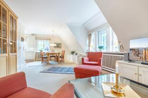 ein Wohnzimmer mit roten Stühlen und einem Tisch in der Unterkunft Tüchter in Keitum