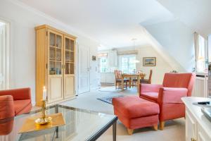 ein Wohnzimmer mit roten Stühlen und einem Tisch in der Unterkunft Tüchter in Keitum